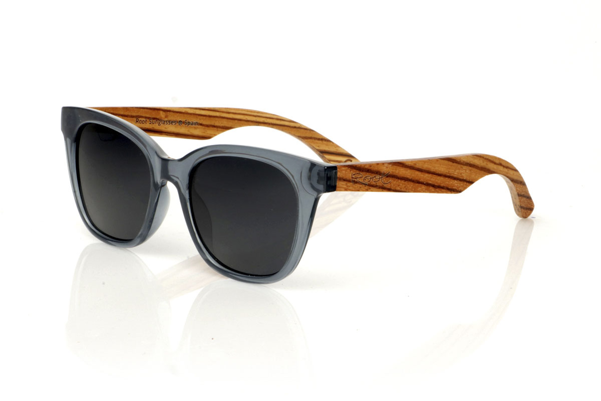 Gafas de Madera Natural de Zebrano GRACE BLUE. Gafas de sol GRACE BLUE: elegantes con un toque contemporáneo. Estas gafas, con su montura azul oscuro grisáceo, tienen una forma sugerente que combina cejas redondeadas con una parte inferior más estrecha, creando un look sofisticado y moderno. Las varillas de madera de Zebrano aportan un contraste natural, resaltando la atención al detalle y la calidad artesanal. Disponibles con lentes grises o en gris degradado, ofrecen protección y claridad bajo cualquier luz. Con una medida de 143x49mm y un calibre de 50, las GRACE BLUE son ideales para quienes buscan destacar con sutileza y elegancia. Haz que cada mirada cuente. Venta al Por Mayor y Detalle | Root Sunglasses® 